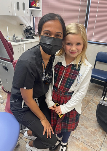 Two dental team members holding I got my vaccine stickers