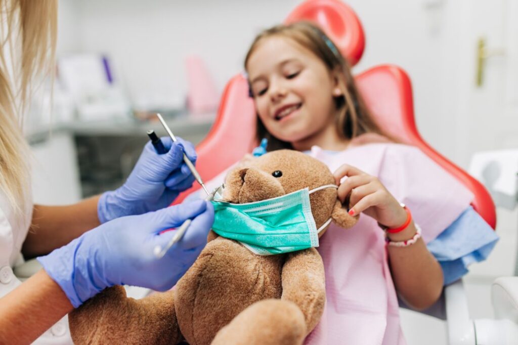 A little girl with a teddy bear at the dentist